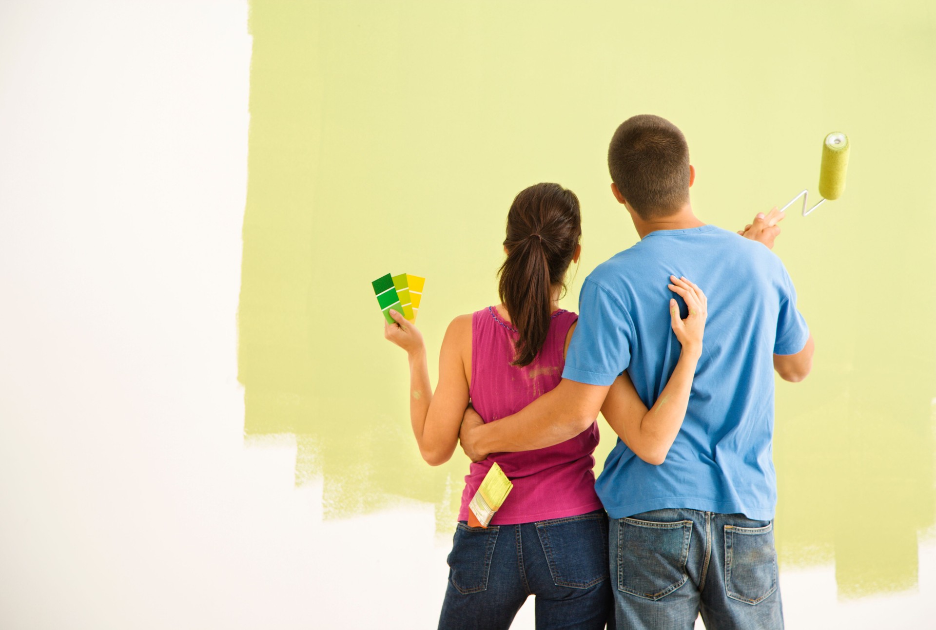 A young couple painting their home together